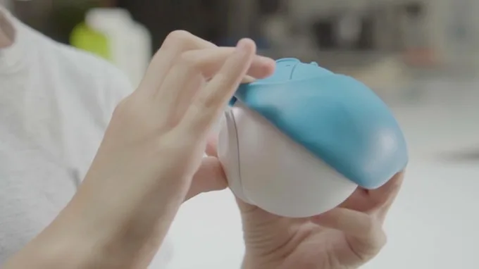 A pair of hands stretching a blue rubber character skin over a Storyball